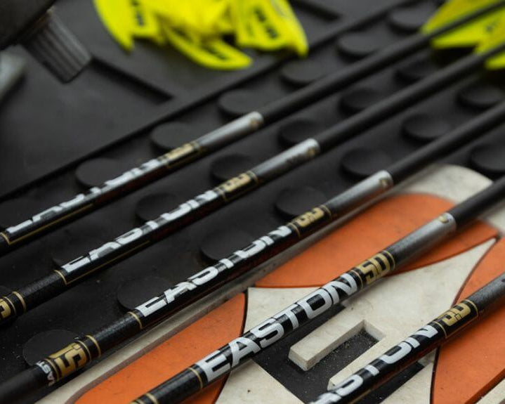 Set of arrows with visible branding on a black and orange mat
